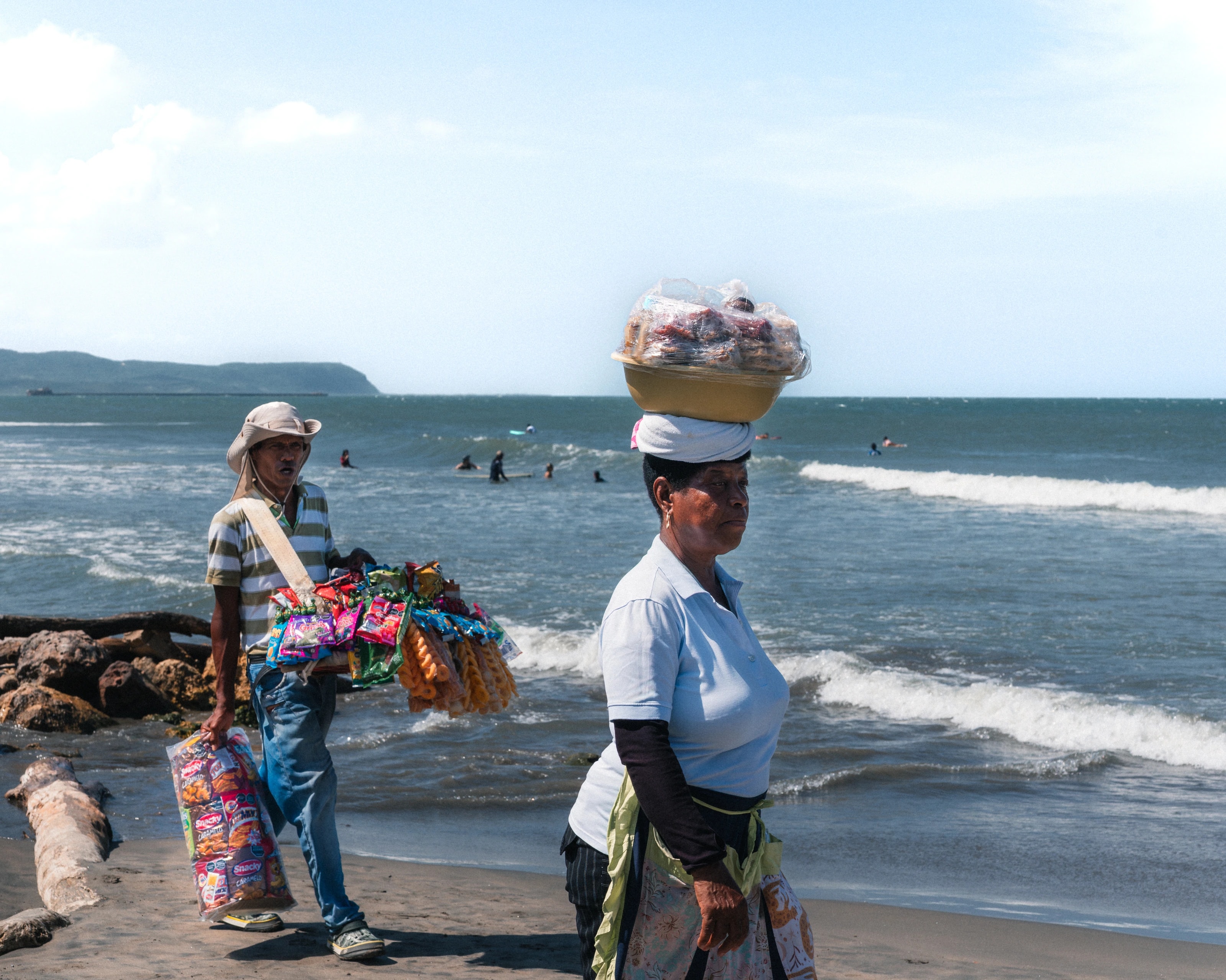 People carrying baskets along the shore