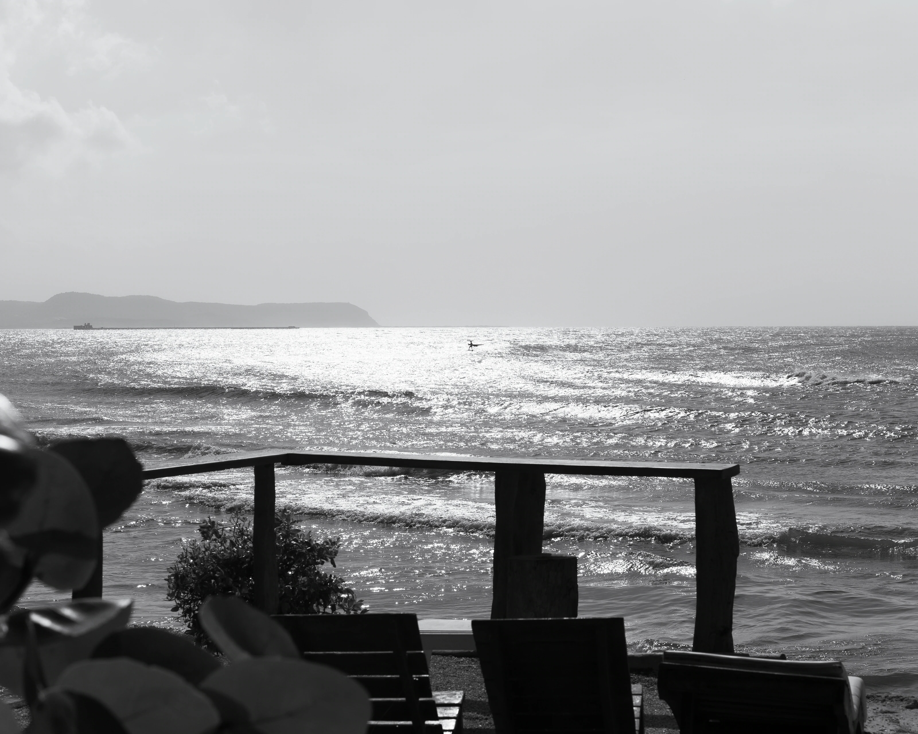 A shaded terrace overlooking the sea in black and white