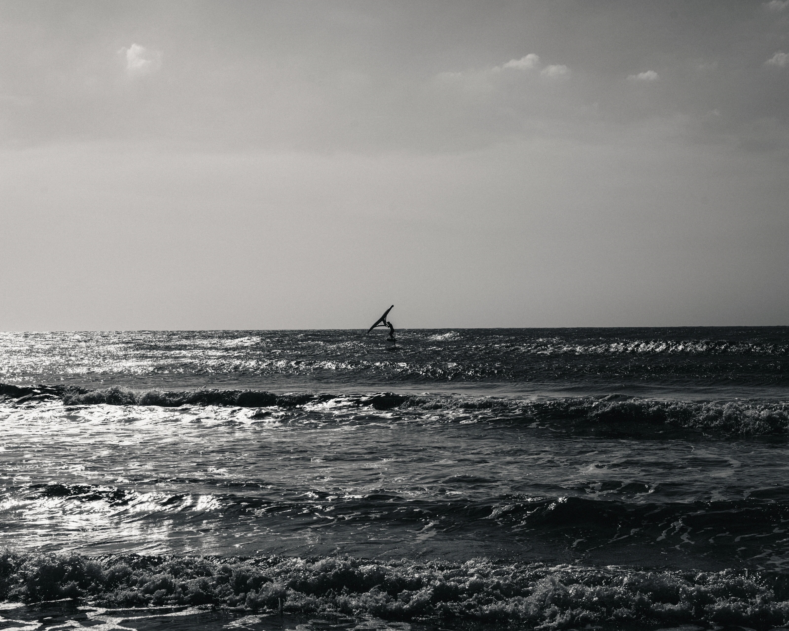A surfer beneath a grey sky