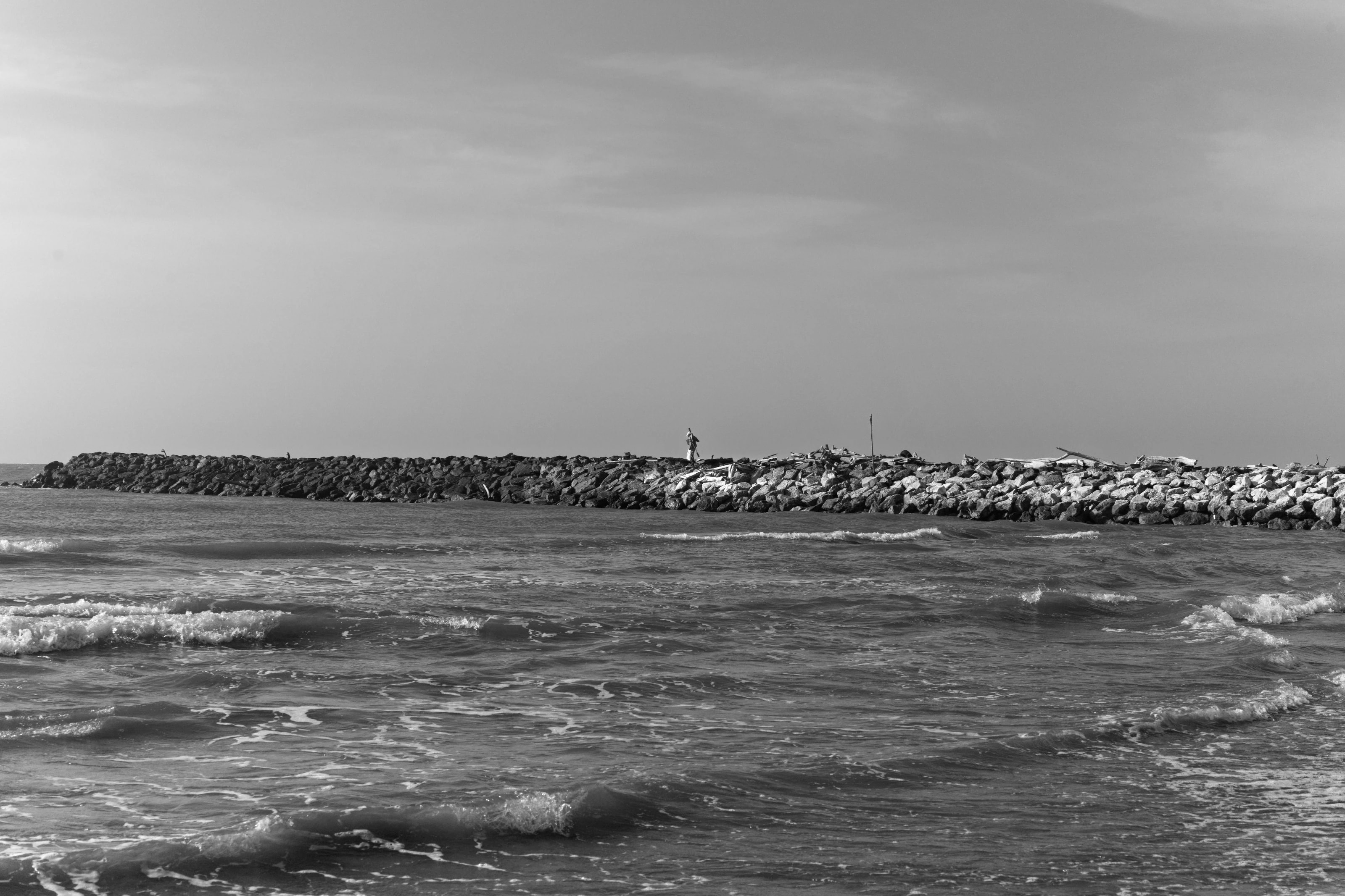 Waves approaching a distant shore in black and white