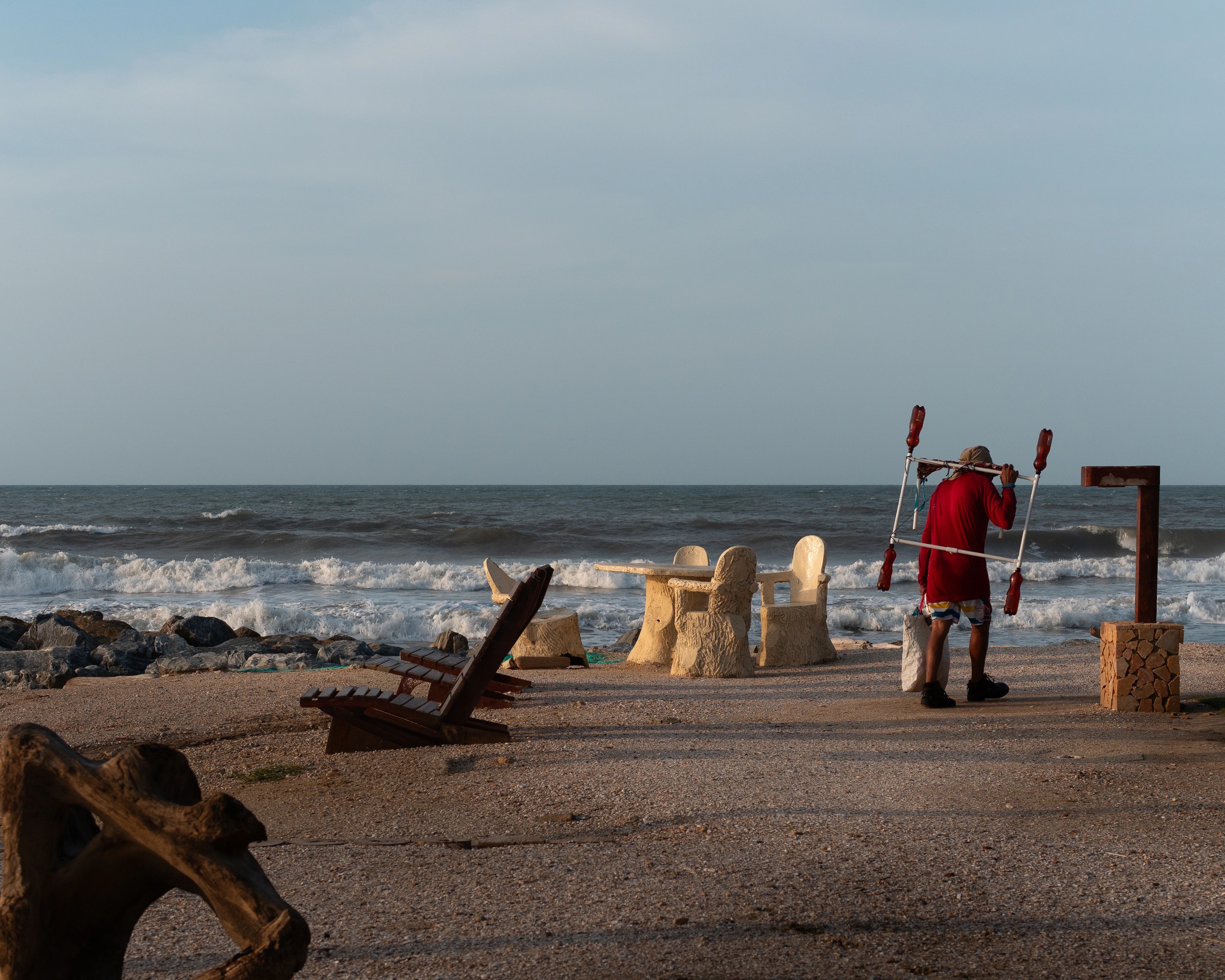 A beach worker beside a stone seawall