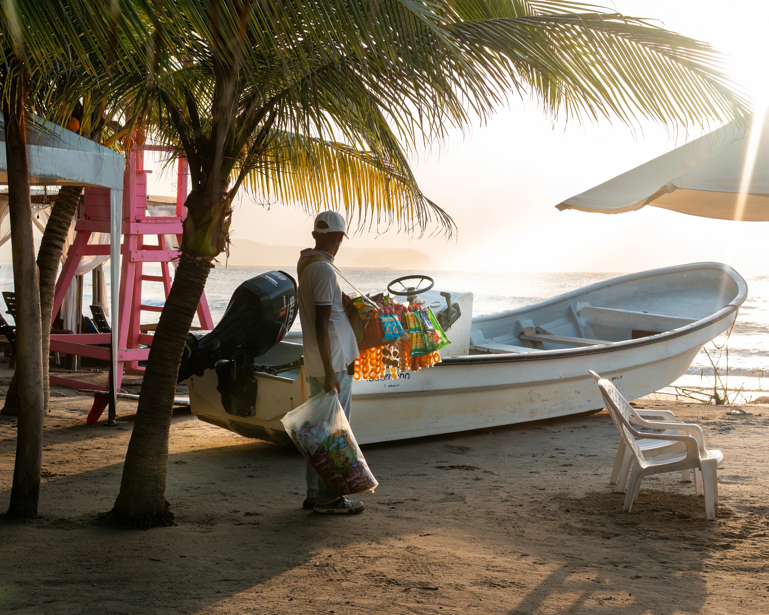 A person passing a boat under palm trees