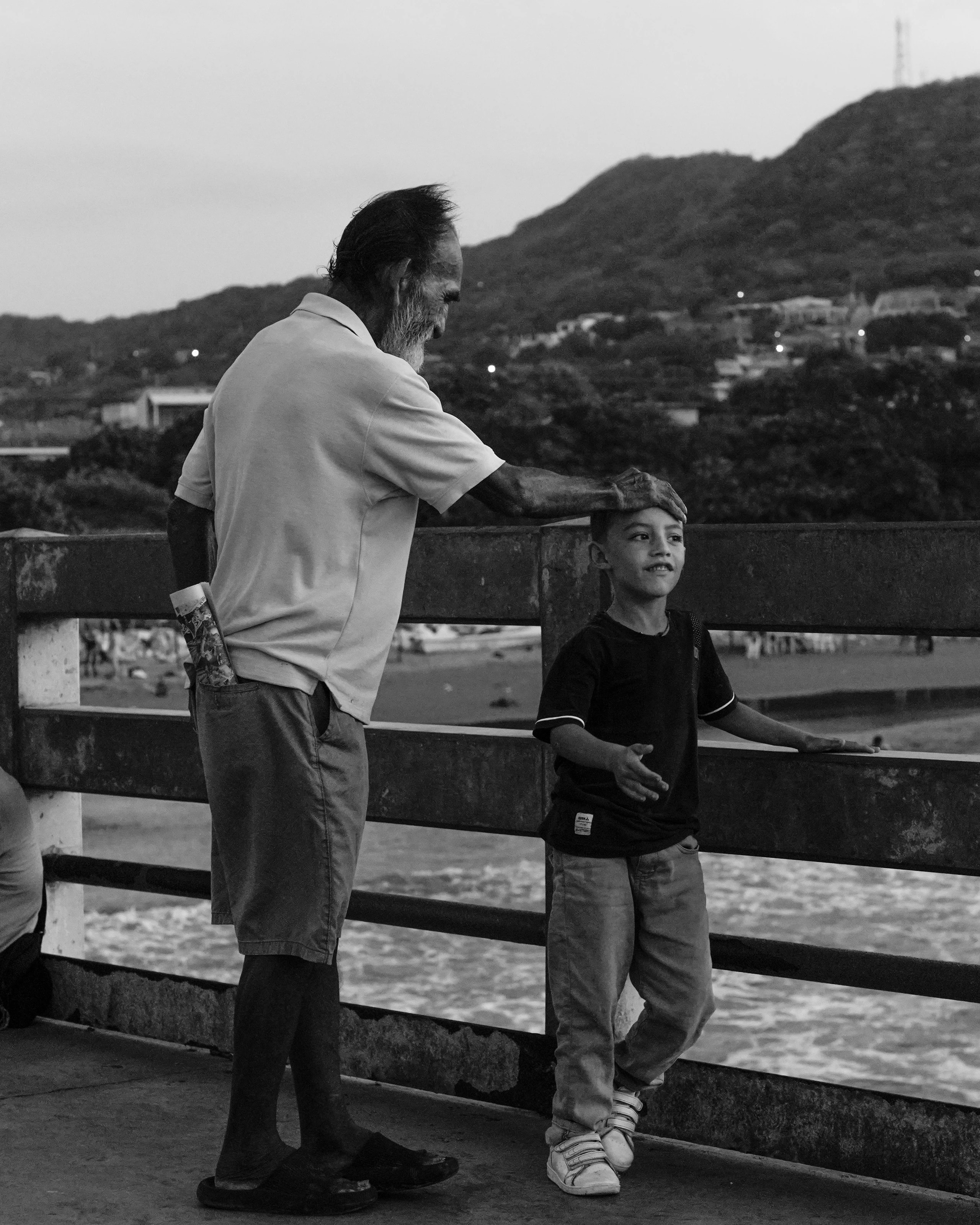A conversation beside a wooden railing in black and white