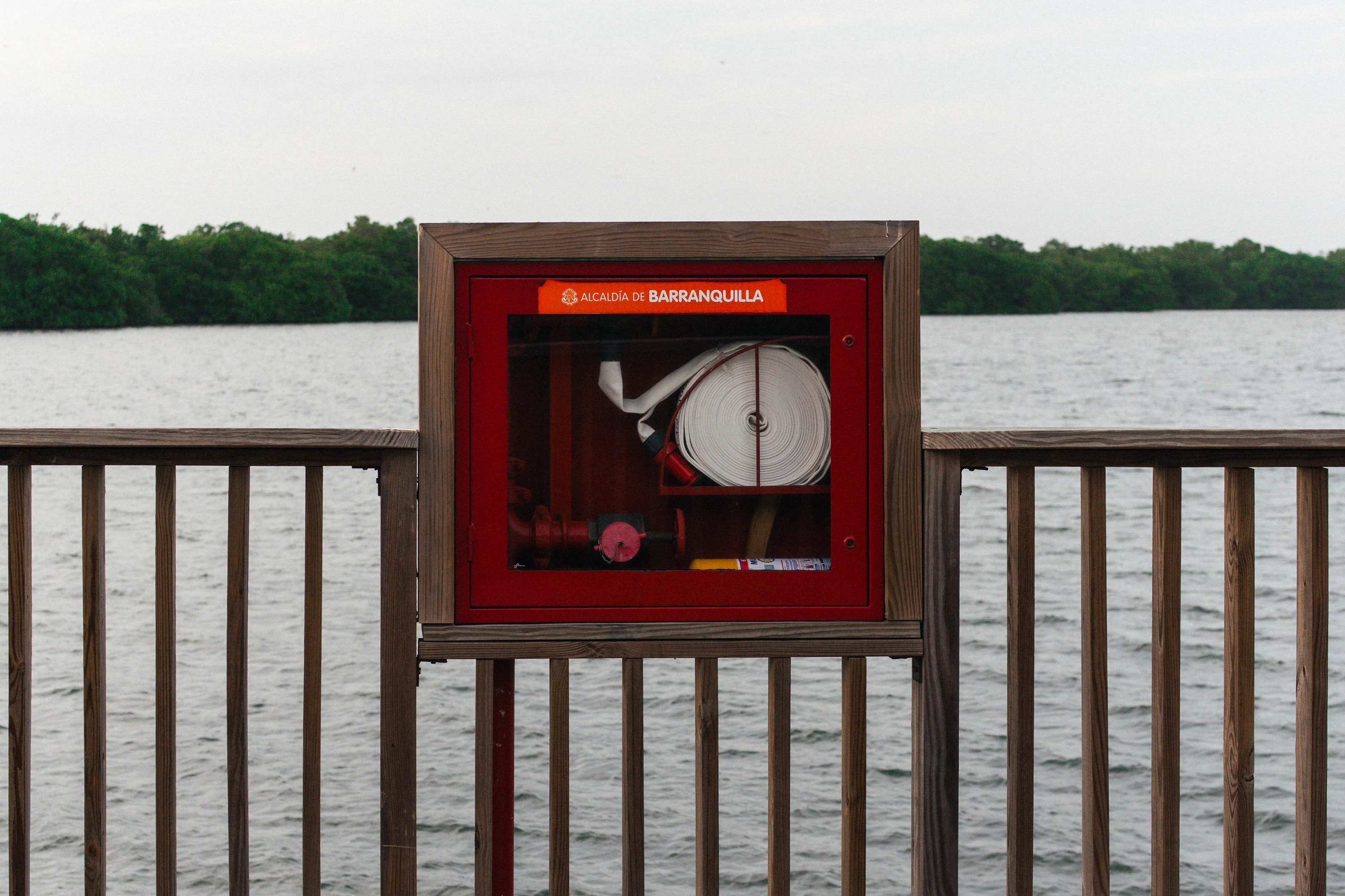 A red display box beside a waterfront railing