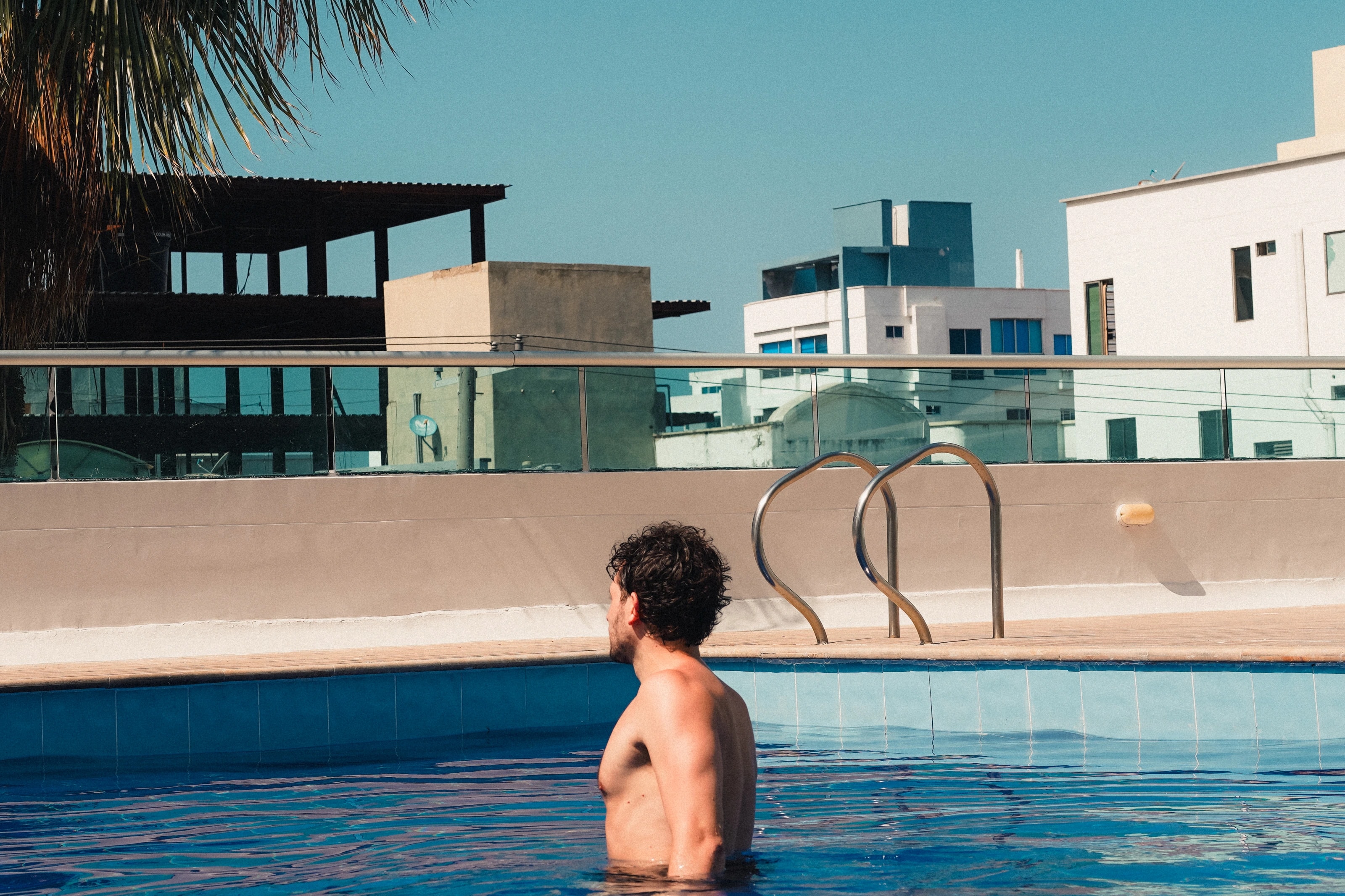 A swimmer beside geometric pool architecture