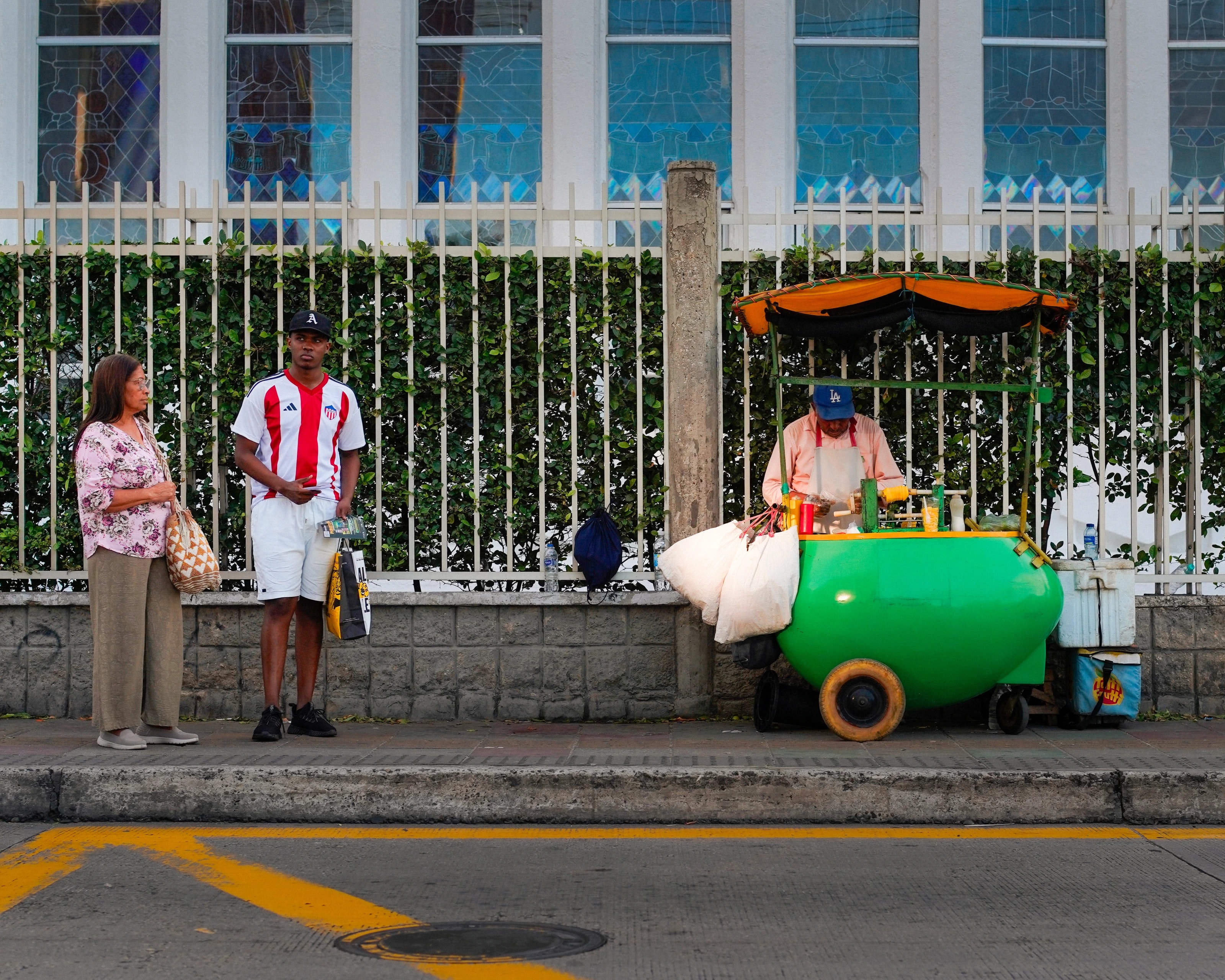 A street vendor beside a bright green cart