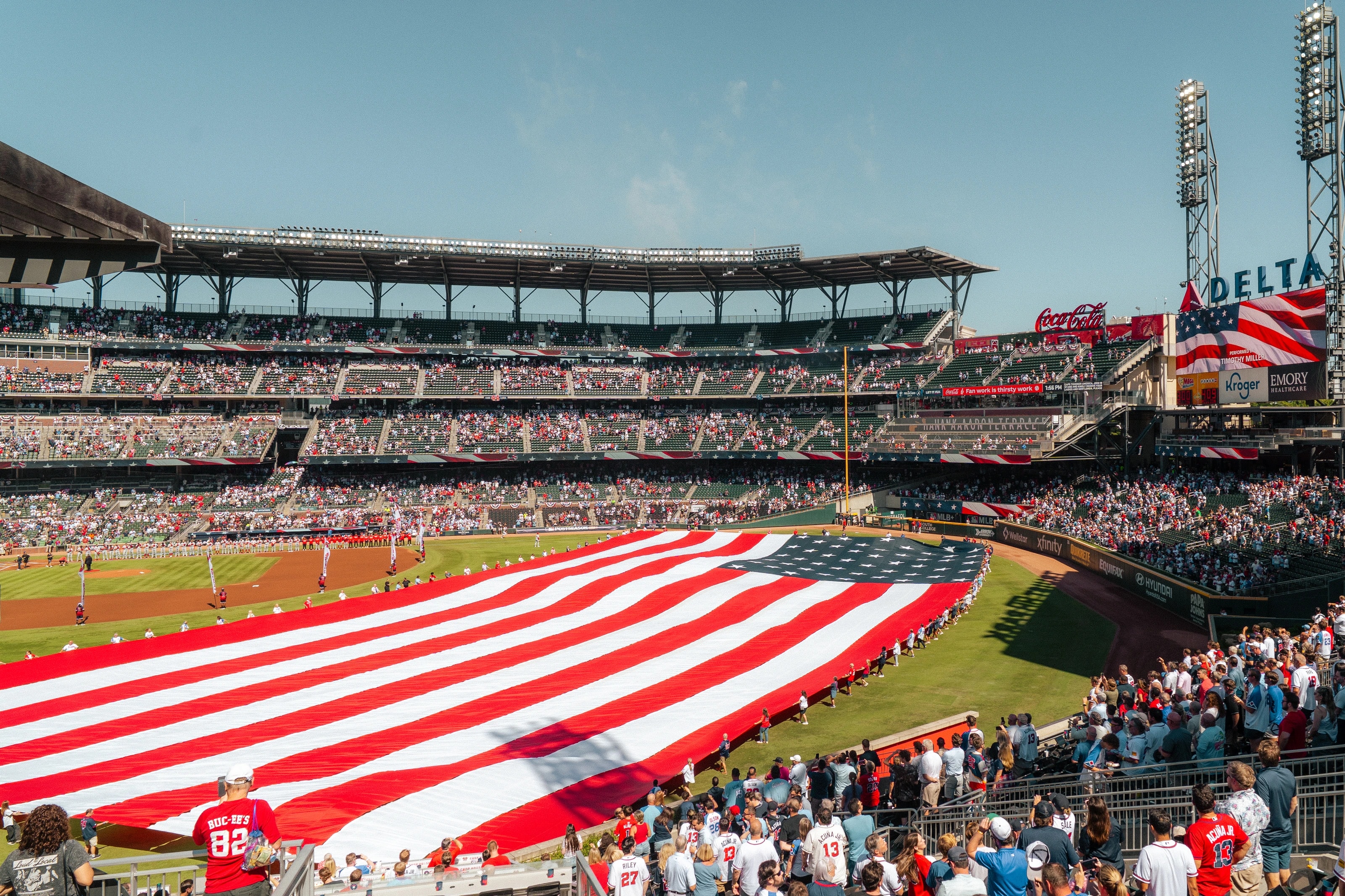 A large flag across a baseball field