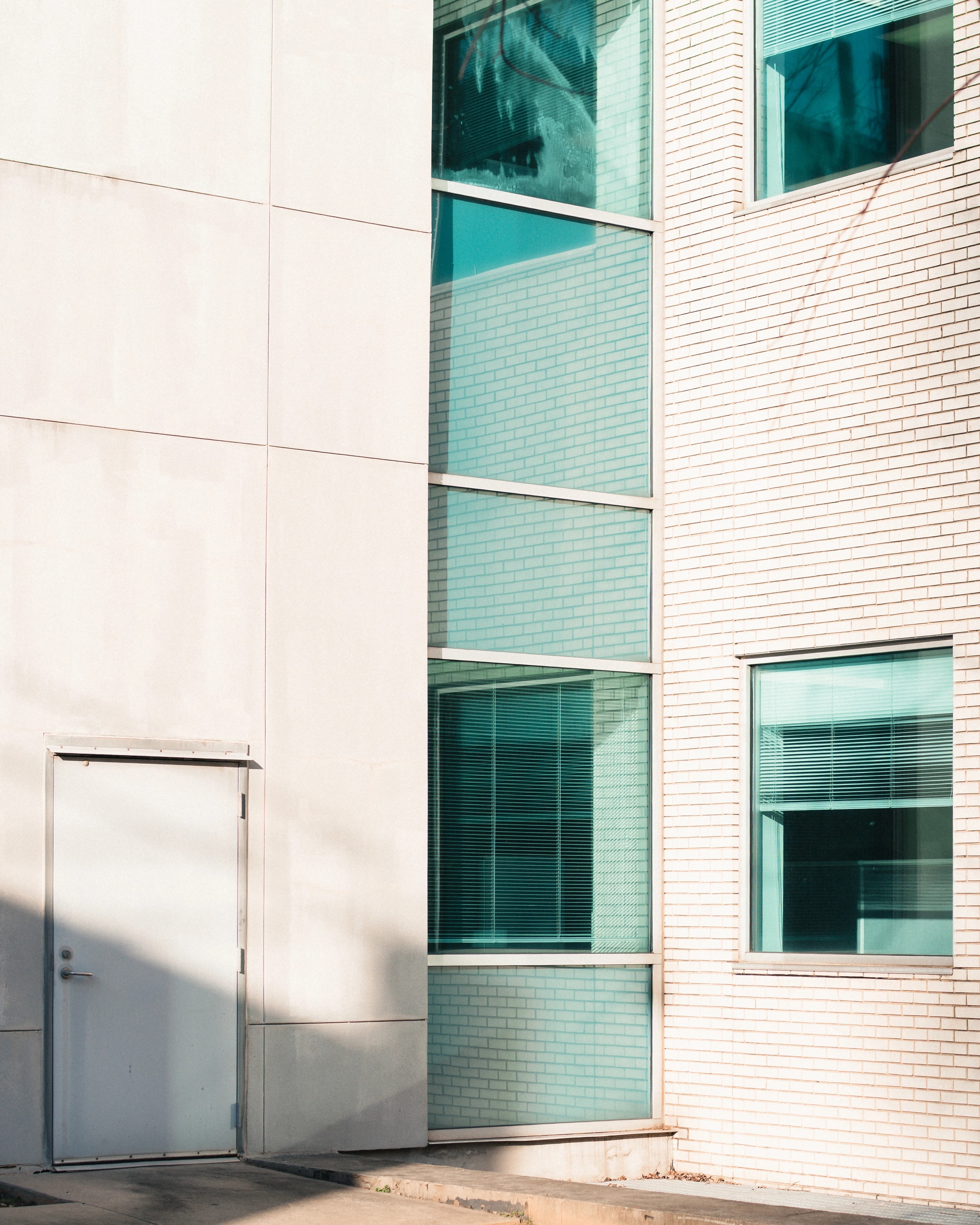 Pale architectural facade with green windows